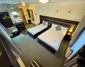 una camera d'albergo con due letti e un camino di Epsilon Hotel a Londra