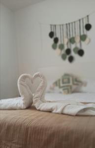 a heart made out of white towels on a bed at Apartamento Murales de Talavera in Talavera de la Reina +14 photos