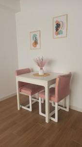a white table and chairs with a vase on it at Apartamento Murales de Talavera in Talavera de la Reina