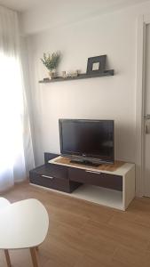 a living room with a flat screen tv on a entertainment center at Apartamento Murales de Talavera in Talavera de la Reina