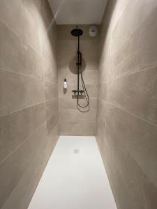 La salle de bains est pourvue d'une douche avec une lumière sur le mur. dans l'établissement COSY TERRASSE 6 pers Ax Thermes Centre Parking, à Ax-les-Thermes