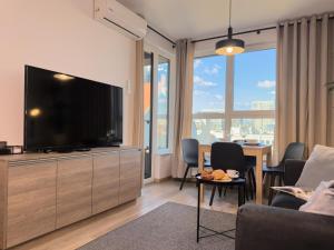 a living room with a large flat screen tv at URBAN APARTMENTS PREMIUM, Opolska 10 No 91, Free Garage, Self Check-in in Katowice