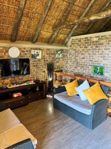 a living room with a couch and a tv at Ingwenya View in Marloth Park +14 photos