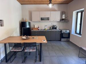 TeméniaにあるPetra Homes Temeniaの小さなキッチン(木製のテーブルと椅子付)