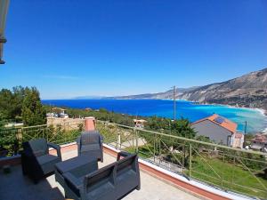 a balcony with two chairs and a view of the water at Villa Alexandros in Zóla