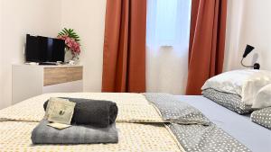 Schlafzimmer mit einem Bett mit einem Kissen und einem TV in der Unterkunft Perello Old Town in Split