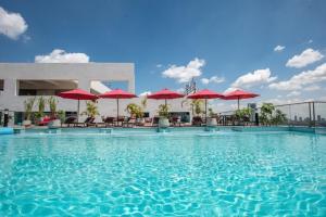 a large swimming pool with red umbrellas on a building at Skynest Residences, 10th floor, Room 1017. in Nairobi