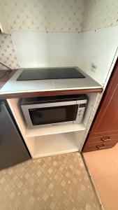 a microwave oven sitting in a cabinet in a kitchen at Mobil Home Saint Jacut De La Mer in Saint-Jacut-de-la-Mer +9 photos