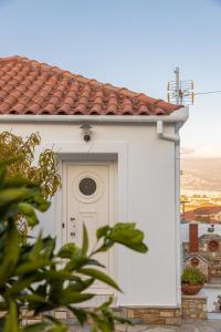 a white building with a door with a window at The courtyard house in Dhimínion