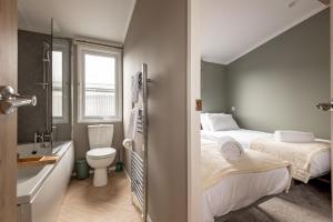 a small bathroom with two beds and a toilet at Lodge No 124 Stewart's Resort Cameron in St. Andrews +22 photos
