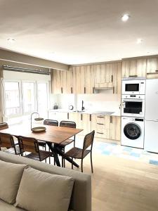 a kitchen with a table and chairs in a room at Soleado 2 in Gijón