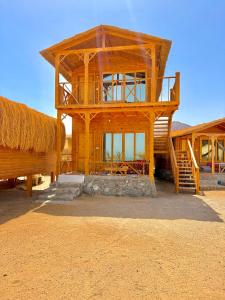 a large wooden building with a straw roof at Love beach camp in Taba