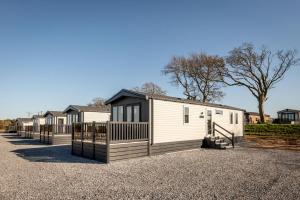 a row of mobile homes on a gravel driveway at Lodge No 124 Stewart's Resort Cameron in St. Andrews