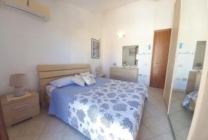 a bedroom with a blue and white bed and a mirror at Casa House Villa Chiara in Pula