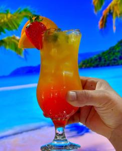 una mano che tiene un drink con fragole e arancio di Epsilon Hotel a Londra