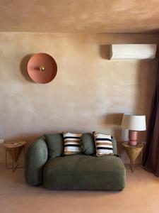 a living room with a green couch with two pillows at Formentera Especial in La Savina
