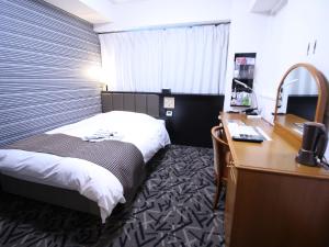 a hotel room with a bed and a desk at APA Hotel Hikoneminami in Hikone