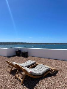 a chaise lounge on a beach next to the water at Formentera Especial in La Savina