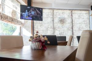 a table with a vase of flowers on top of it at Pensiunea Caramida Verde in Craiova