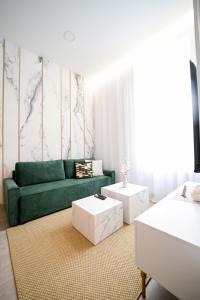 Una sala de estar con un sofá verde y dos mesas blancas. en PAM22 Two bedroom Apartment, en Zagreb