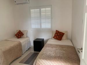 a bedroom with two beds and a window at PortzVue Villa in Saint Peter