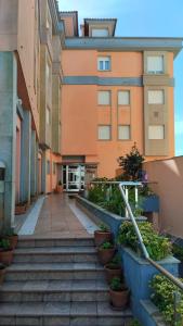 schody prowadzące do budynku z roślinami doniczkowymi w obiekcie Apartamentos Dunamar w mieście Noalla
