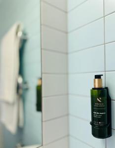 a bottle of mouthwash on a bathroom wall at Green Park Hotel Klaipeda in Klaipėda