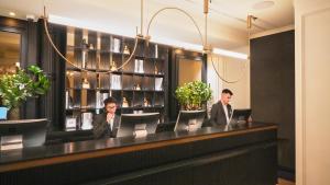 two people sitting at a bar with their laptops at Hotel Regina in Madrid