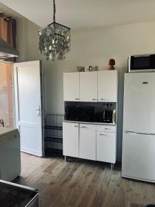 a kitchen with white cabinets and a black microwave at Appartement avec terrasse privative in Celles-sur-Plaine +14 photos