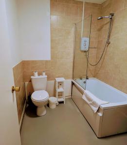 y baño con aseo, bañera y ducha. en OYO Aparthotel Hathern - Loughborough, en Hathern
