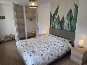 a bedroom with a bed and a painting on the wall at la petite pause normande in Lengronne