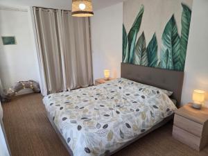 a bedroom with a bed and a painting on the wall at la petite pause normande in Lengronne
