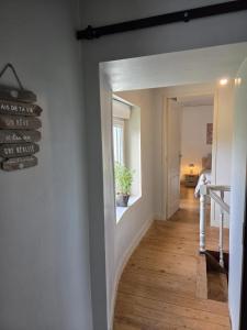 a hallway with a sign that reads as be true we have one friend at la petite pause normande in Lengronne +2 photos