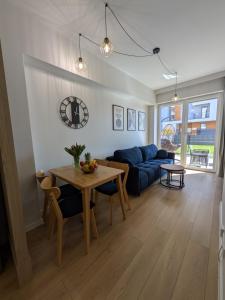 un soggiorno con un tavolo e un divano blu di Magic Apartments - Zibi a Zator