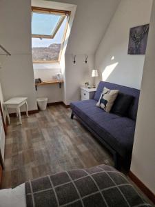 a living room with a blue couch and a window at Applecross B&B and Luxury Self Catering Cabins free parking in Applecross