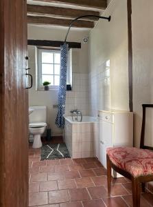 ein Badezimmer mit Badewanne, Toilette und Waschbecken in der Unterkunft Le charme de l'ancien au calme et à 8 min de Chenonceaux in La Croix-en-Touraine