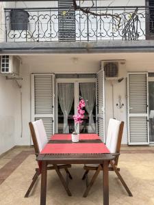 a wooden table with chairs and a vase with pink flowers on it at Splendid Luxury Apartments in Budva +27 photos