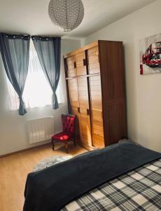 a bedroom with a bed and a cabinet and a chair at Appartement avec terrasse privative in Celles-sur-Plaine