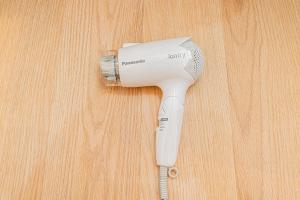 a hair dryer sitting on top of a wooden table at Akabanestay A 志茂 in Tokyo