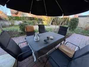 クサンテンにあるFerienhaus Magnolie Xantenのパティオ(パラソルの下にテーブルと椅子付) +14枚の写真