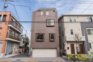 a tall brick building with windows and a garage at Akabanestay A 志茂 in Tokyo
