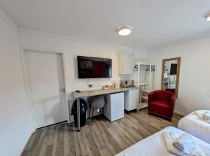 a hotel room with a desk and a red chair at OYO Aparthotel Hathern - Loughborough in Hathern