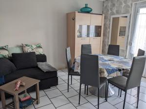 a living room with a couch and a table at Appart spacieux 2 chambres in Fort-Mahon-Plage