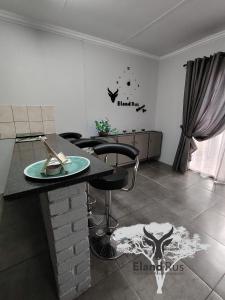 a living room with a table and some chairs at Eland Rus Micro Stay Self Catering in Kathu +11 photos