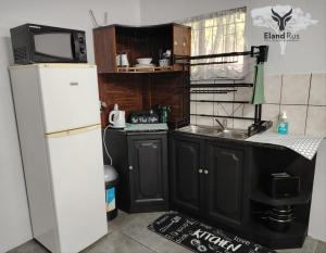 a small kitchen with a refrigerator and a sink at Eland Rus Micro Stay Self Catering in Kathu