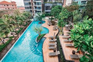 Sea View High Flr,2 Bed Room Exclusive At Pattaya في جنوب باتايا: مسبح لا متناهي في منتجع مع كراسي استرخاء