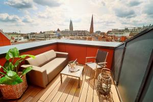 - un balcon avec un canapé et une table sur le toit dans l'établissement Nena Apartments Bremen, à Brême