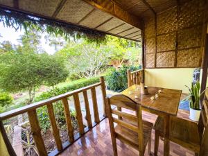 a wooden table and chair on a balcony at Cecilia's Garden Guesthouse in Siquijor
