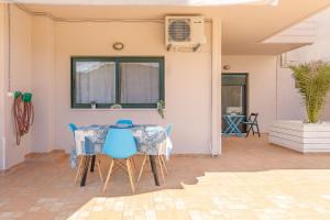 a dining room with a table and blue chairs at Lucia's Home in Stalos