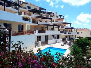 a large apartment building with a swimming pool at Sunset Apartment in Peyia